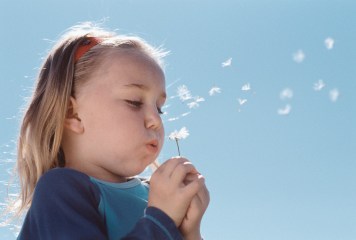 Girl Blowing on a Dandelion